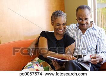 Stock Photo - couple on sofa 
in modern home 
with magazine. 
fotosearch - search 
stock photos, 
pictures, images, 
and photo clipart
