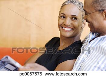 Stock Image - couple on sofa 
in modern home 
with magazine. 
fotosearch - search 
stock photos, 
pictures, images, 
and photo clipart