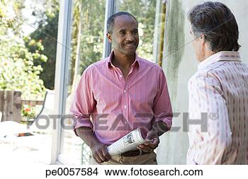 Stock Photo - two men outdoors 
one holding newspaper. 
fotosearch - search 
stock photos, 
pictures, images, 
and photo clipart