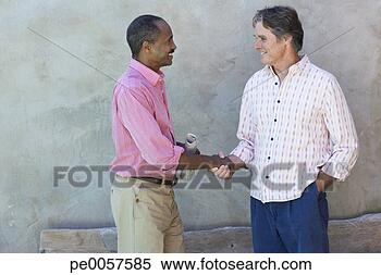 Stock Image - two men outdoors 
by a wooden bench 
shaking hands. 
fotosearch - search 
stock photos, 
pictures, images, 
and photo clipart
