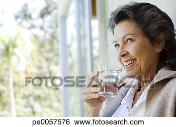 Stock Photo - woman with glass 
of water standing 
in doorway. fotosearch 
- search stock 
photos, pictures, 
images, and photo 
clipart