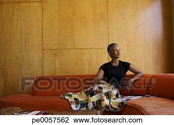 Stock Photo - woman sitting 
on sofa in modern 
home. fotosearch 
- search stock 
photos, pictures, 
images, and photo 
clipart