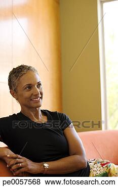 Stock Photo - woman sitting 
on sofa in modern 
home. fotosearch 
- search stock 
photos, pictures, 
images, and photo 
clipart