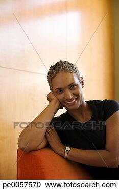 Stock Photography - woman sitting 
on sofa in modern 
home relaxing. 
fotosearch - search 
stock photos, 
pictures, images, 
and photo clipart