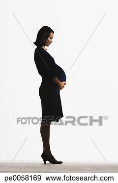 Stock Photograph - woman standing 
holding her pregnant 
stomach. fotosearch 
- search stock 
photos, pictures, 
images, and photo 
clipart