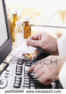 Stock Photo - doctor with bag 
of pills at computer. 
fotosearch - search 
stock photos, 
pictures, images, 
and photo clipart