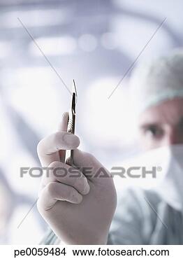 Stock Photo - doctor holding 
a scalpel in foreground. 
fotosearch - search 
stock photos, 
pictures, images, 
and photo clipart