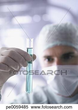 Stock Image - doctor holding 
test tube in foreground. 
fotosearch - search 
stock photos, 
pictures, images, 
and photo clipart