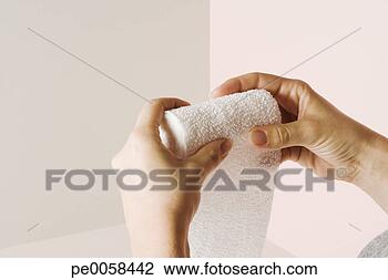 Stock Photo - a roll of gauze 
sitting being 
rolled back up 
by two hands. 
fotosearch - search 
stock photos, 
pictures, images, 
and photo clipart