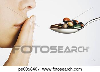 Picture - woman with hand 
to mouth blocking 
spoonful of pills. 
fotosearch - search 
stock photos, 
pictures, images, 
and photo clipart