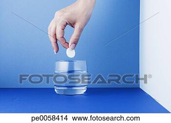 Stock Photo - woman placing 
a tablet in a 
glass of water. 
fotosearch - search 
stock photos, 
pictures, images, 
and photo clipart