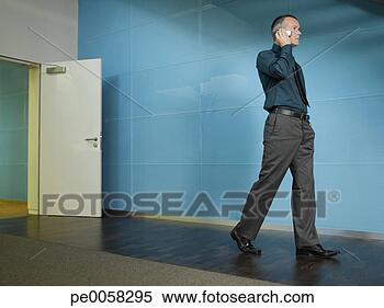 Stock Image - businessman on 
mobile phone in 
blue office. fotosearch 
- search stock 
photos, pictures, 
images, and photo 
clipart