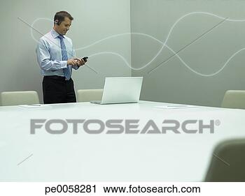 Stock Photography - businessman standing 
with mobile phone 
with bright line 
is attaching. 
fotosearch - search 
stock photos, 
pictures, images, 
and photo clipart
