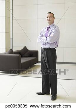 Stock Image - businessman standing 
in office hall 
by couch. fotosearch 
- search stock 
photos, pictures, 
images, and photo 
clipart