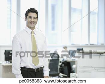 Stock Photo - businessman standing 
in office smiling 
with co-worker 
in background. 
fotosearch - search 
stock photos, 
pictures, images, 
and photo clipart