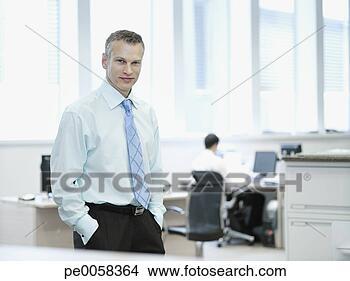 Stock Photo - businessman standing 
in office smiling 
with co-worker 
in background. 
fotosearch - search 
stock photos, 
pictures, images, 
and photo clipart