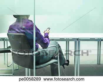 Stock Photograph - businesswoman 
sitting at desk 
with mobile phone. 
fotosearch - search 
stock photos, 
pictures, images, 
and photo clipart