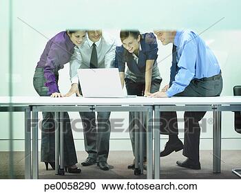 Stock Photography - four businesspeople 
in office looking 
at laptop. fotosearch 
- search stock 
photos, pictures, 
images, and photo 
clipart