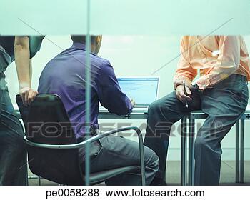 Stock Photo - three businesspeople 
in an office at 
a laptop. fotosearch 
- search stock 
photos, pictures, 
images, and photo 
clipart