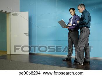Stock Photo - two businessmen 
with a laptop 
in blue office. 
fotosearch - search 
stock photos, 
pictures, images, 
and photo clipart