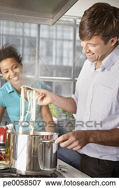 Picture - couple cooking 
meal in kitchen. 
fotosearch - search 
stock photos, 
pictures, images, 
and photo clipart