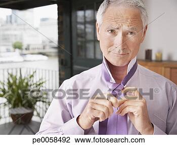 Stock Photo - man doing up tie 
in bedroom. fotosearch 
- search stock 
photos, pictures, 
images, and photo 
clipart