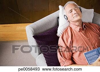 Stock Photo - man wearing headphones 
sleeping on sofa 
with book. fotosearch 
- search stock 
photos, pictures, 
images, and photo 
clipart