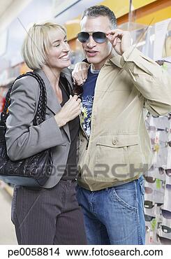 Stock Photo - couple trying 
on sunglasses 
in store. fotosearch 
- search stock 
photos, pictures, 
images, and photo 
clipart