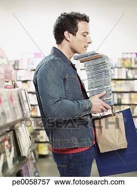 Picture - man carrying stack 
of cds in store. 
fotosearch - search 
stock photos, 
pictures, images, 
and photo clipart