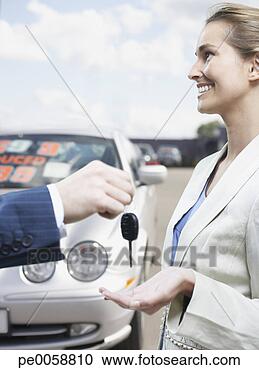 Stock Photography - man handing woman 
keys in car lot. 
fotosearch - search 
stock photos, 
pictures, images, 
and photo clipart