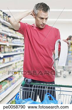 Stock Photography - man looking at 
bill in grocery 
store. fotosearch 
- search stock 
photos, pictures, 
images, and photo 
clipart