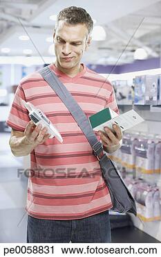 Stock Photography - man looking at 
electronics in 
store. fotosearch 
- search stock 
photos, pictures, 
images, and photo 
clipart