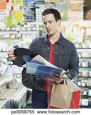 Stock Image - man looking at 
record in store. 
fotosearch - search 
stock photos, 
pictures, images, 
and photo clipart