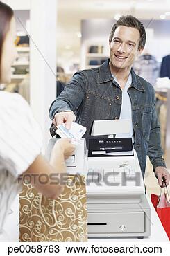Stock Photo - man paying for 
items at a cashier 
in store. fotosearch 
- search stock 
photos, pictures, 
images, and photo 
clipart