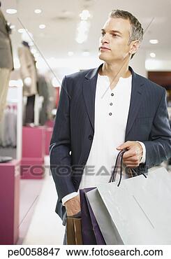 Picture - man with shopping 
bags in store. 
fotosearch - search 
stock photos, 
pictures, images, 
and photo clipart