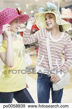 Stock Photograph - two girls trying 
on hats in store. 
fotosearch - search 
stock photos, 
pictures, images, 
and photo clipart