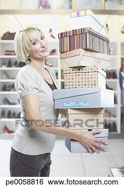 Stock Photo - woman carrying 
stack of shoe 
boxes in store. 
fotosearch - search 
stock photos, 
pictures, images, 
and photo clipart