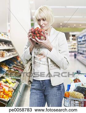 Stock Photo - woman holding 
strawberries grocery 
shopping. fotosearch 
- search stock 
photos, pictures, 
images, and photo 
clipart
