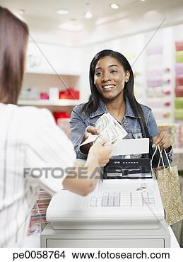 Stock Photo - woman paying for 
items at a cashier 
in store. fotosearch 
- search stock 
photos, pictures, 
images, and photo 
clipart