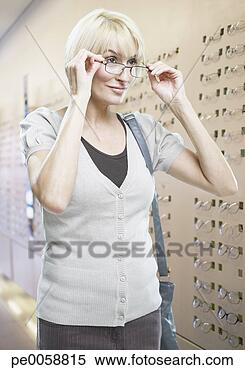 Stock Image - woman trying on 
eyeglasses in 
store. fotosearch 
- search stock 
photos, pictures, 
images, and photo 
clipart