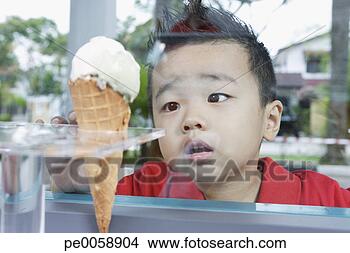 Stock Photo - boy looking at 
ice cream cone 
through glass. 
fotosearch - search 
stock photos, 
pictures, images, 
and photo clipart