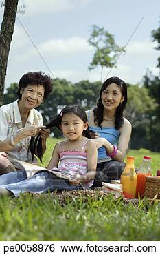 Stock Photo - two women braiding 
young girl's hair 
in park. fotosearch 
- search stock 
photos, pictures, 
images, and photo 
clipart