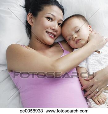 Stock Photo - woman with baby 
in bed. fotosearch 
- search stock 
photos, pictures, 
images, and photo 
clipart