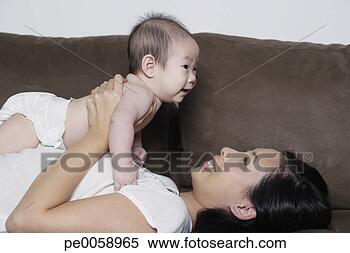 Stock Image - woman and baby 
lying back on 
sofa. fotosearch 
- search stock 
photos, pictures, 
images, and photo 
clipart
