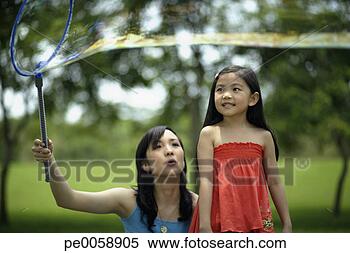 Stock Image - woman and girl 
with large bubble 
wand. fotosearch 
- search stock 
photos, pictures, 
images, and photo 
clipart
