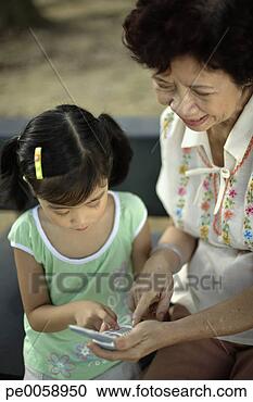 Stock Photography - woman and young 
girl looking at 
mobile phone. 
fotosearch - search 
stock photos, 
pictures, images, 
and photo clipart