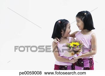 Stock Photo - two young girls 
holding flowers. 
fotosearch - search 
stock photos, 
pictures, images, 
and photo clipart