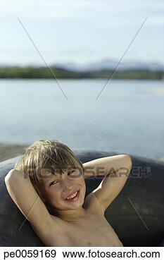 Stock Photograph - boy in inner tube 
by dock. fotosearch 
- search stock 
photos, pictures, 
images, and photo 
clipart