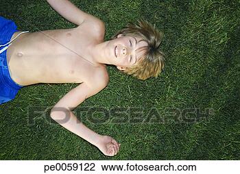 Stock Photo - boy lying outdoors 
in grass. fotosearch 
- search stock 
photos, pictures, 
images, and photo 
clipart