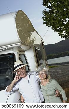 Stock Photograph - couple leaning 
against recreational 
vehicle. fotosearch 
- search stock 
photos, pictures, 
images, and photo 
clipart